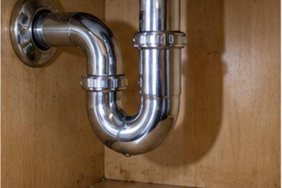 Chrome sink drain and the P-trap beneath a bathroom basin